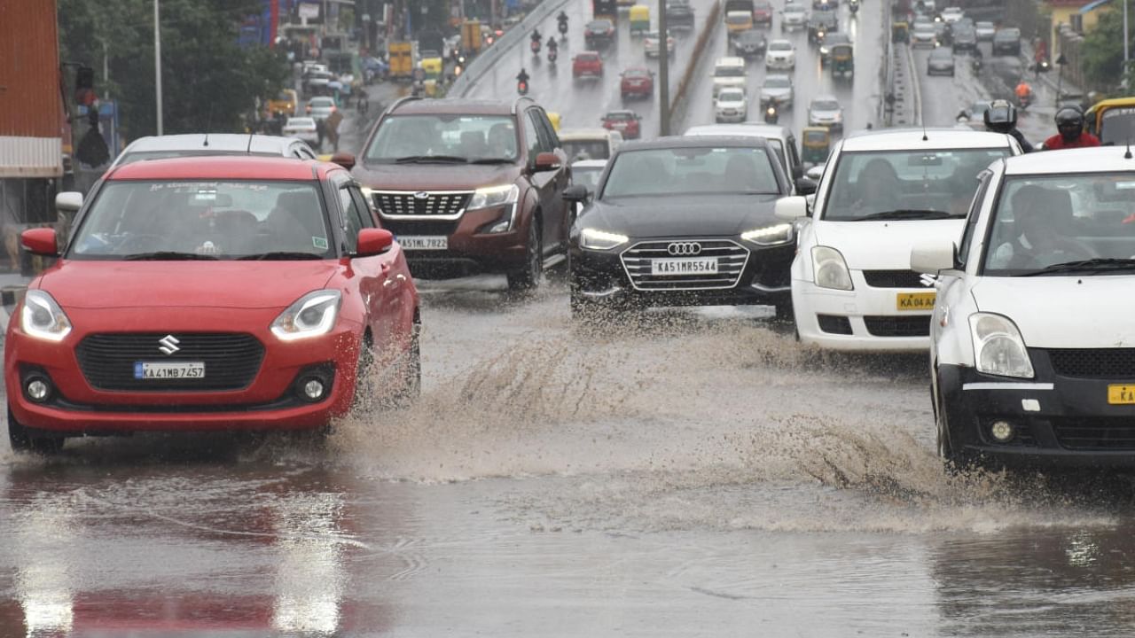 Vehicles moving through a waterlogged road near Ganganagar flyover following monsoon rain in Bengaluru on Wednesday. Credit: DH Photo/BK Janardhan