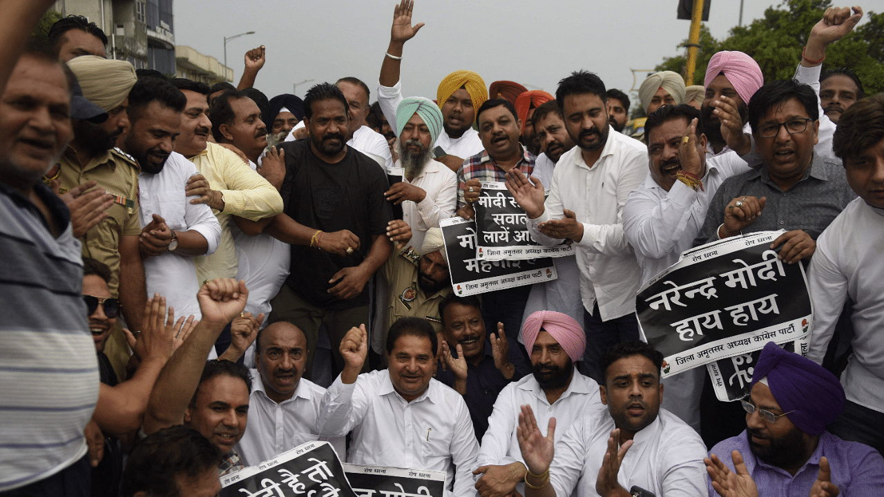 Congress party activists and supporters shout slogans and display placards during a protest in Punjab. Credit: AFP Photo