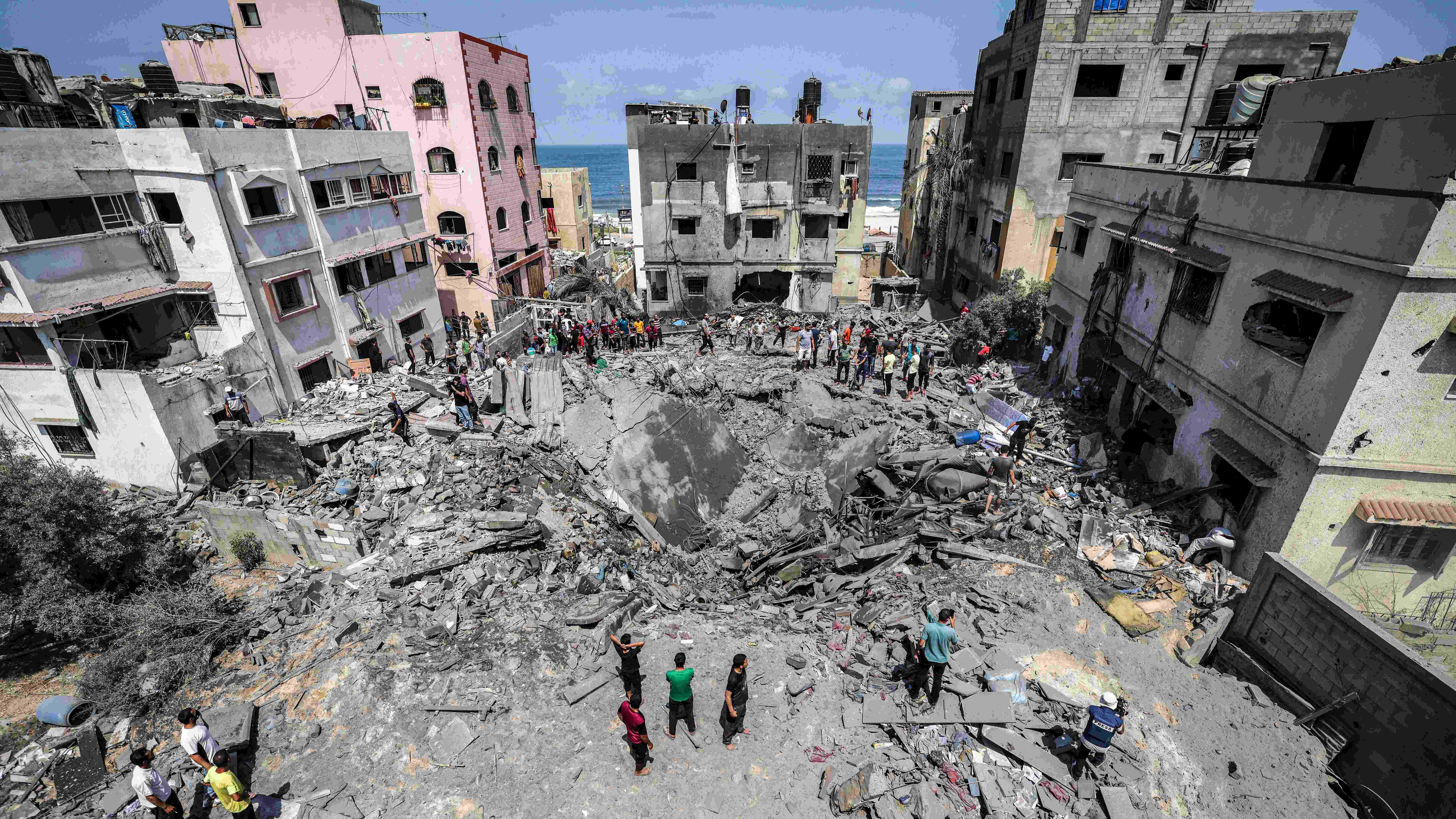 Palestinians inspect the ruins of a collapsed building destroyed by an Israeli air strike in Gaza City. Credit: AFP Photo