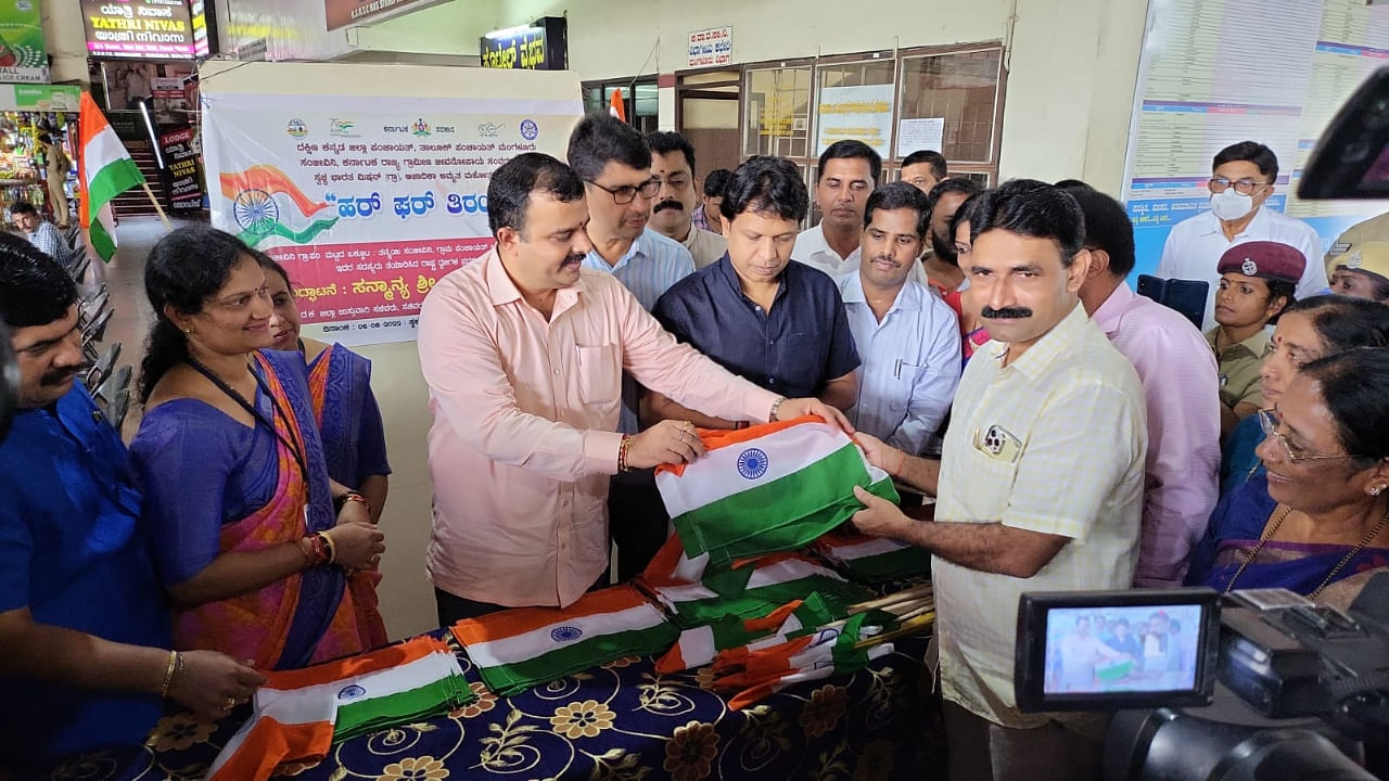District -in-Charge Minister Sunil Kumar hands over the tricolour flag to Chief whip of council in Mangaluru City Corporation Sudheer Shetty in Mangaluru. Credit: Information department photo