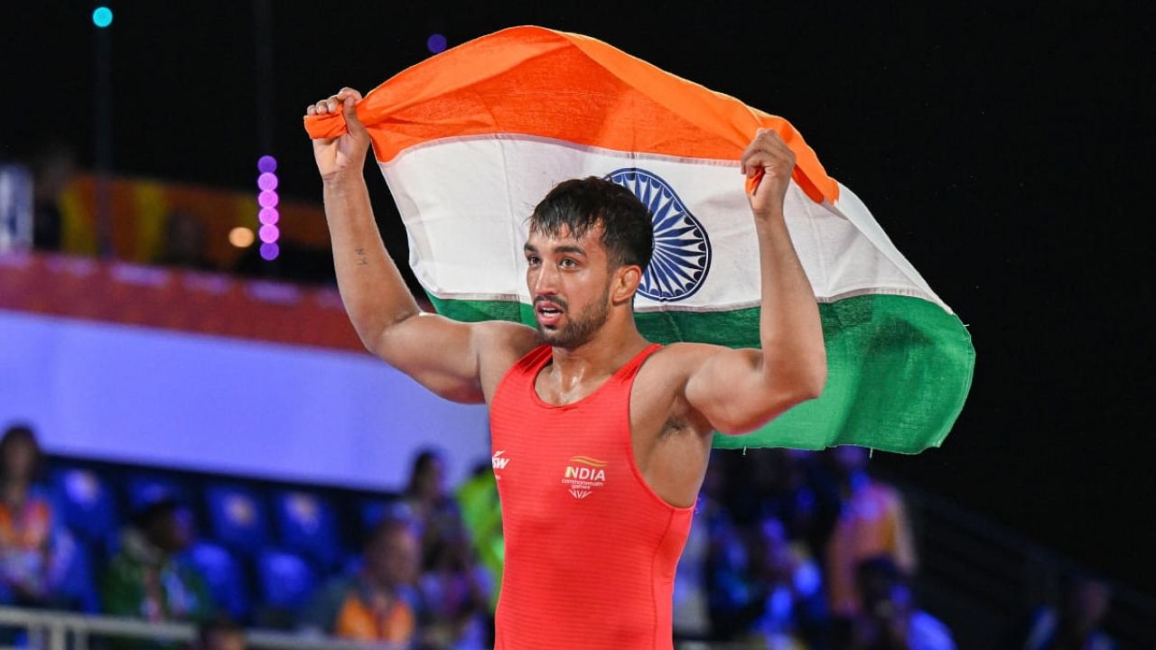 Gold medallist Naveen Kumar holds the tricolor after winning the final of Men's Freestyle Wrestling 74kg event at the Commonwealth Games (CWG), in Birmingham, UK, Saturday, Aug. 6, 2022. Credit: PTI Photo