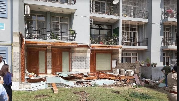 The illegally constructed wall and balcony of Shrikant Tyagi have been broken by the bulldozer of the Noida Authority. Credit: IANS Photo