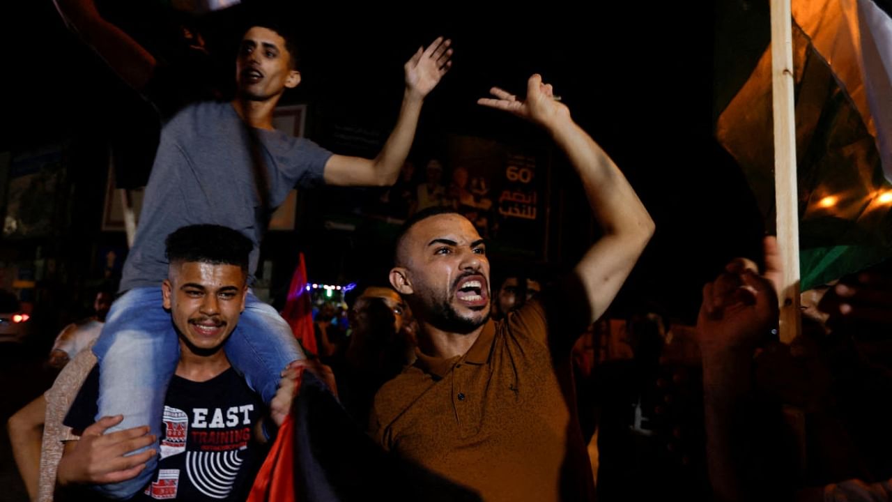 Palestinians celebrate on a street after a ceasefire was announced, in Gaza City. Credit: Reuters Photo