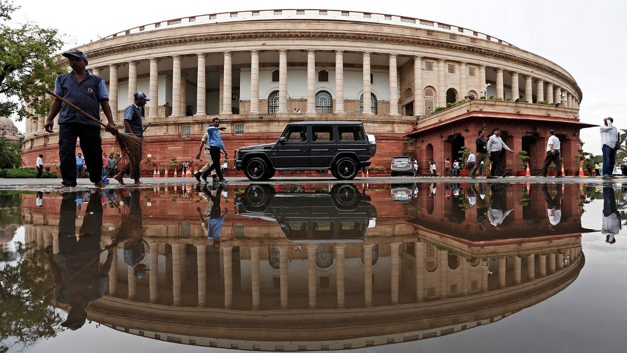 Indian parliament building is reflected in a puddle. Credit: Reuters Photo