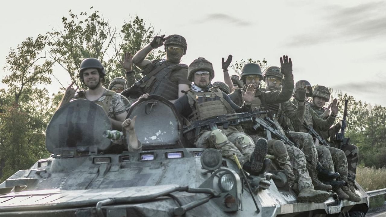 Ukranian soldiers sit a top of an armoured vehicle as it drives to frontline on the outskirts of Bakhmut, eastern Ukraine. Credit: AFP Photo