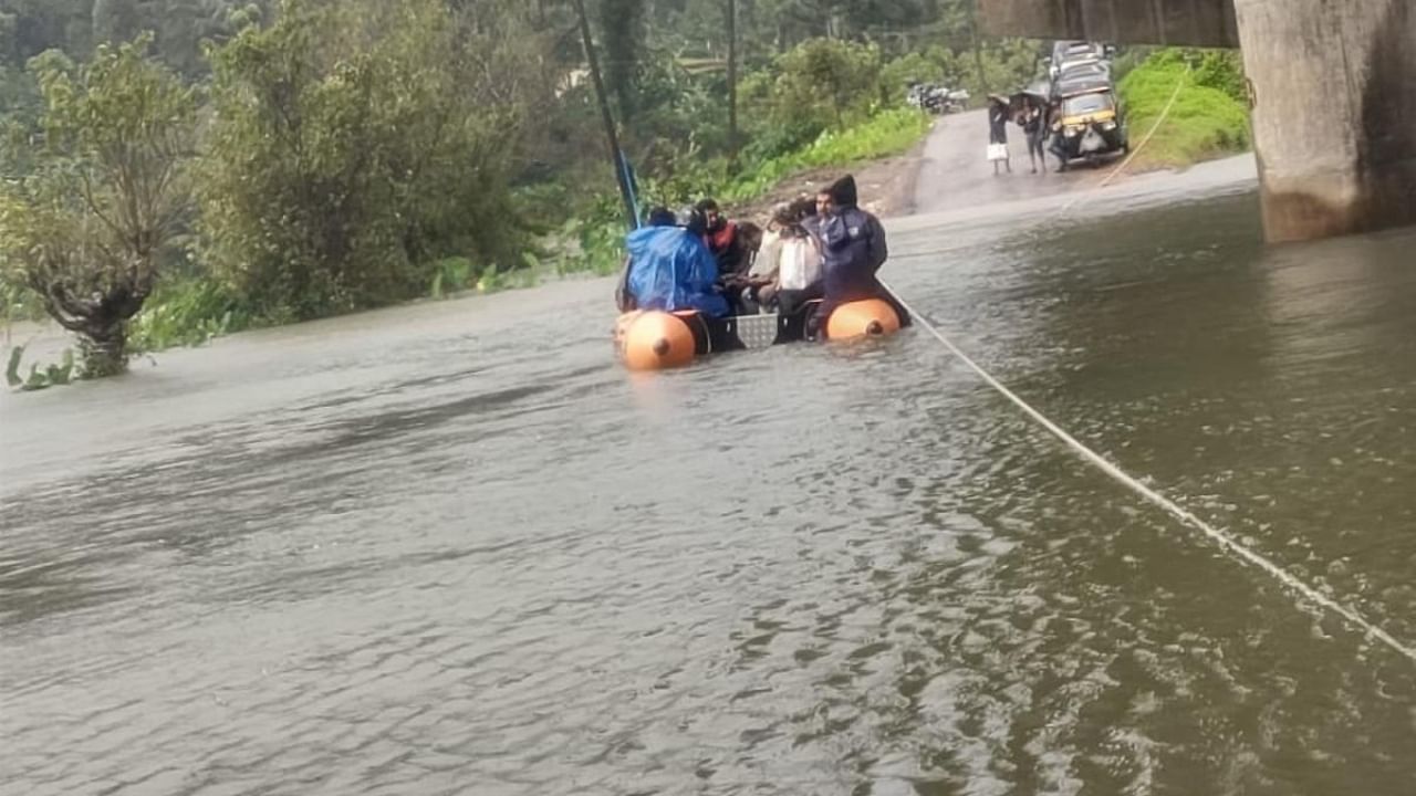 Rubber dinghies are pressed into service to ferry people on Bhagamandala-Napoklu Road in Kodagu district on Monday. Credit: DH Photo