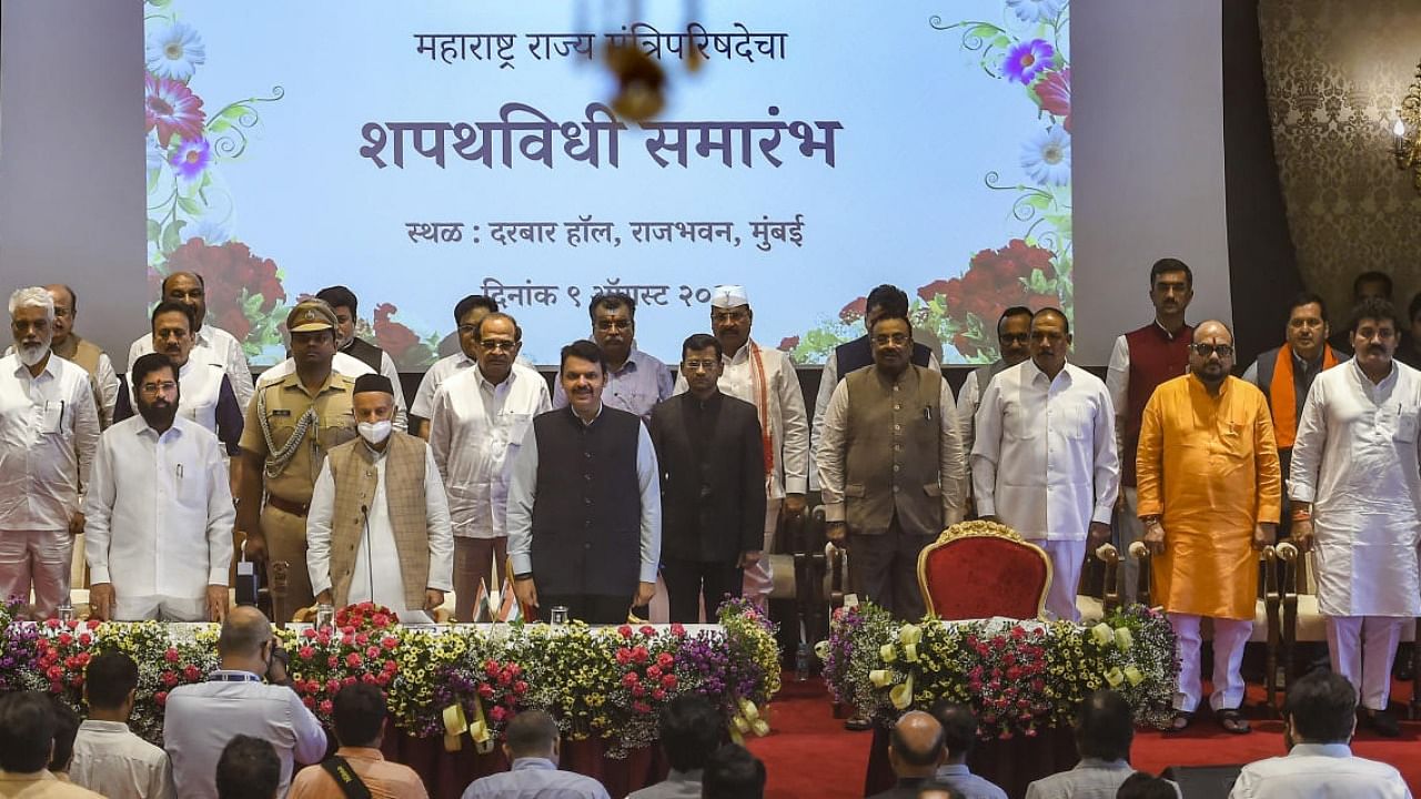 Maharashtra Governor Bhagat Singh Koshyari, Chief Minister Eknath Shinde and Dy CM Devendra Fadnavis with newly sworn-in ministers, at a ceremony at Raj Bhavan in Mumbai. Credit: PTI Photo
