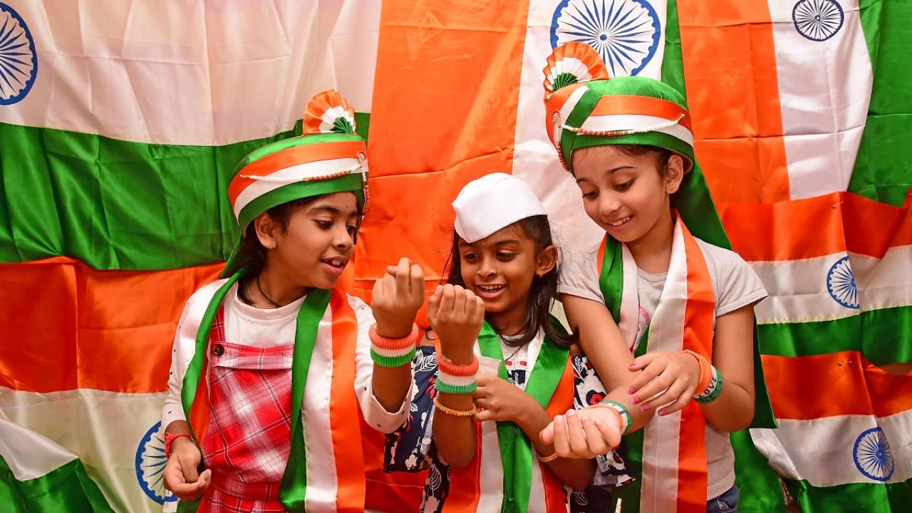 Children buy the Tricolour and other merchandise ahead of Independence Day in Balepet, Chickpet. Credit: DH Photo