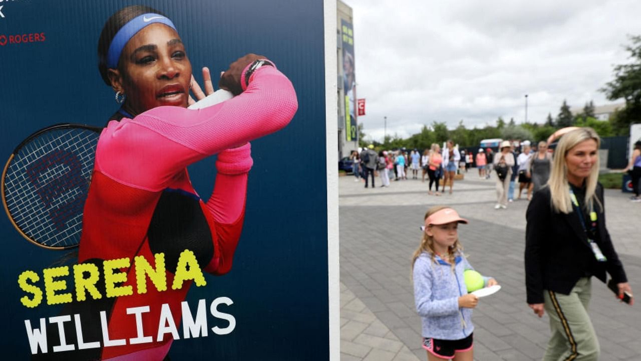 People pass a poster advertising the match of veteran tennis player Serena Williams, who said that she plans to retire after the 2022 U.S. Open, outside a stadium at the National Bank Open in Toronto, Ontario, Canada August 9, 2022. Credit: Reuters Photo