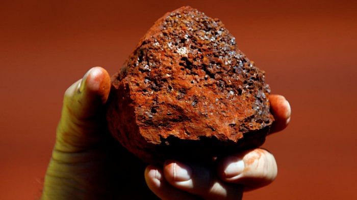 A miner holds a lump of iron ore. Credit: Reuters Photo