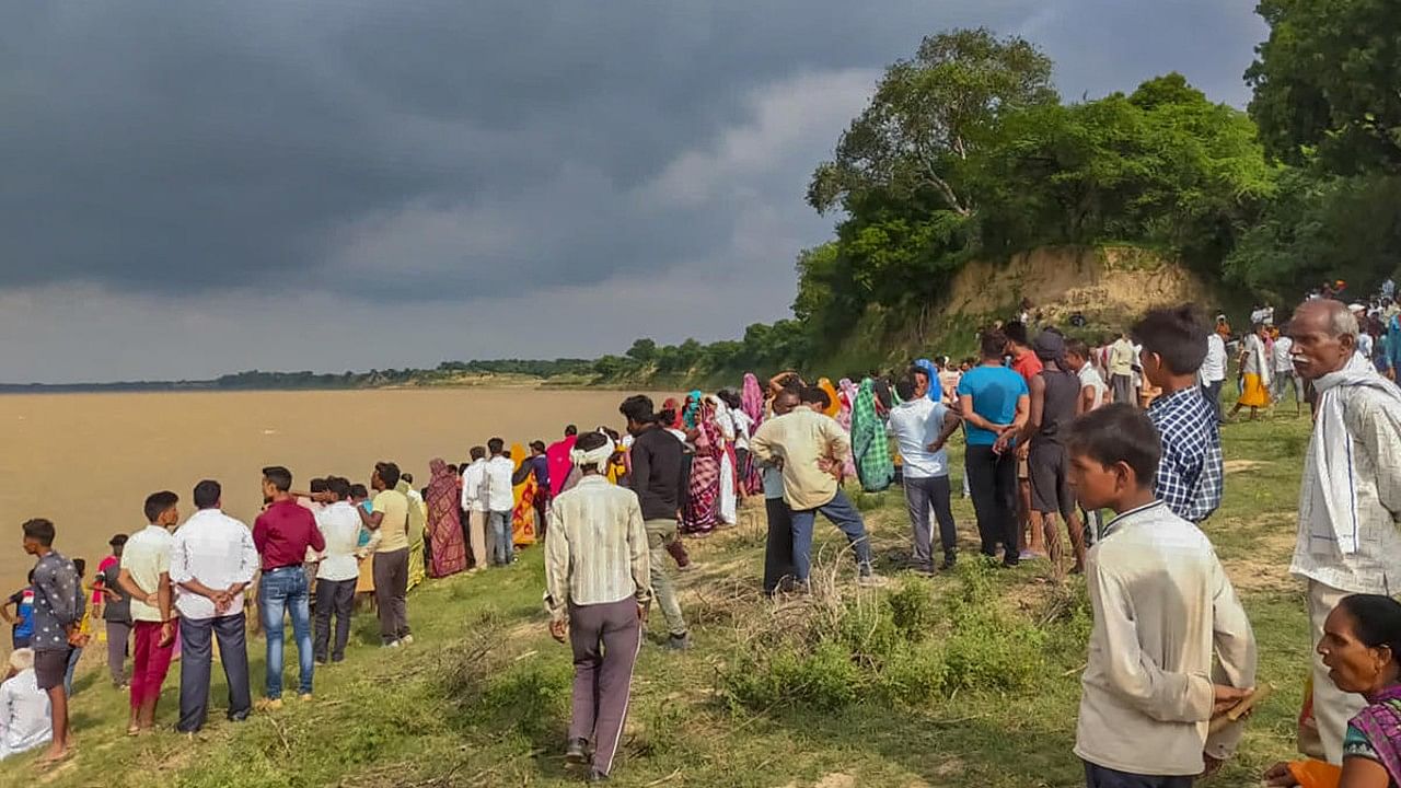 People gather along the banks of Yamuna river after a boat capsized, at Marka area in Banda district. Credit: PTI Photo