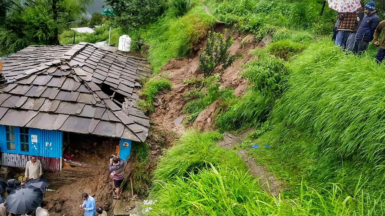 People near a damaged house following flash flood triggered by incessant monsoon rains in Ani subdivision of Kullu, Thursday, Aug 11, 2022. Credit: PTI Photo