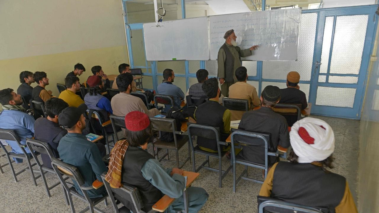 Members of the Taliban with their classmates attend an economic faculty class at a private university in Kabul. Credit: AFP Photo