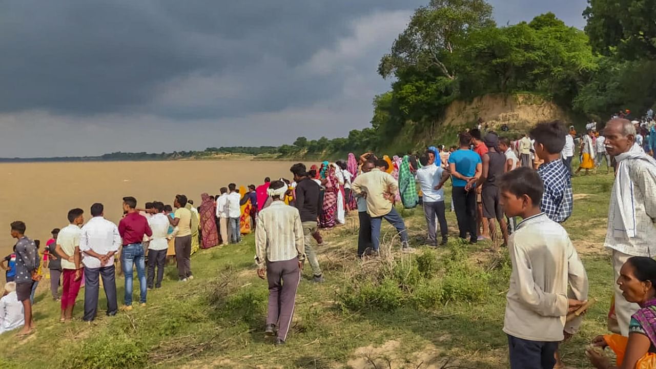 People gather along the banks of Yamuna river after a boat capsized, at Marka area in Banda district, Thursday, Aug. 11, 2022. Credit: PTI Photo