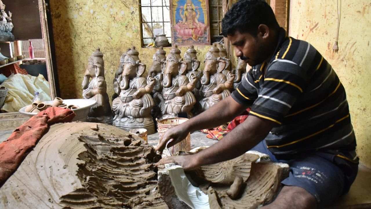 An artisan gives final touches to a Ganesha idol in Pottery Town. Credit: DH Photo/B K Janardhan