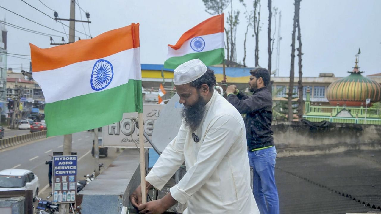 People hoist the national flag at their homes as part of 'Har Ghar Tiranga' campaign under 'Azadi Ka Amrit Mahotsav' celebrations to commemorate 75 years of Indian independence, in Chikmagalur. Credit: PTI Photo