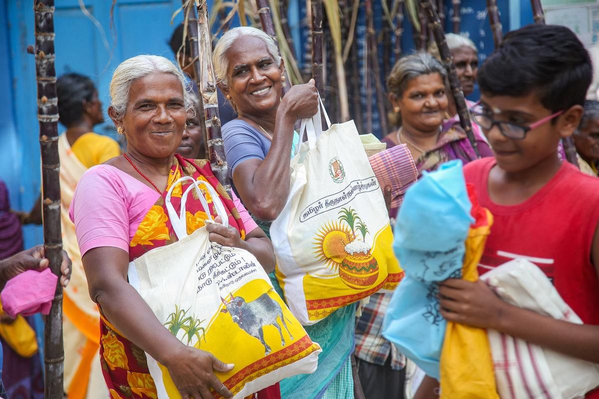 Women take home Pongal kits with twenty items and sugarcane from a ration shop under a Tamil Nadu government scheme in Kanyakumari early this year. (PTI Photo)