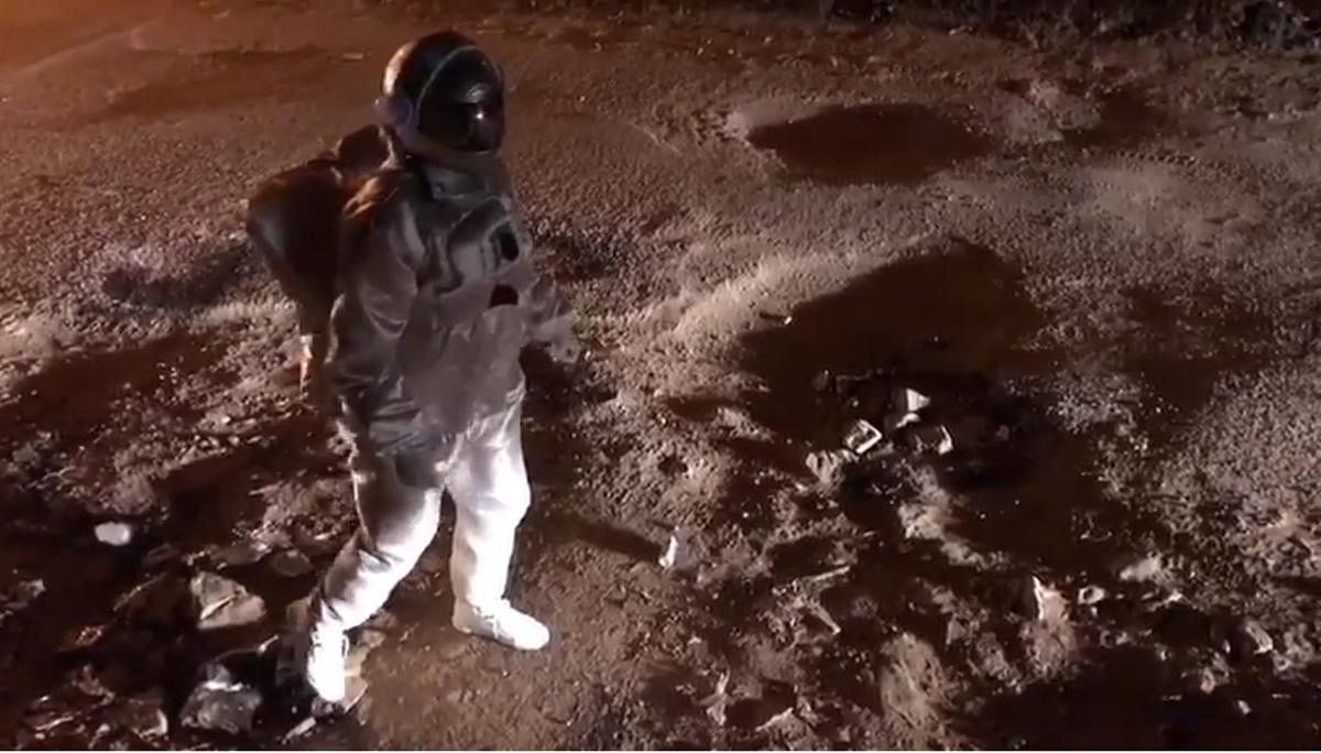 Artist Baadal Nanjundaswamy strolled on the potholed roads of Bengaluru like an astronaut walking on the craters of the moon. Credit: Special Arrangement