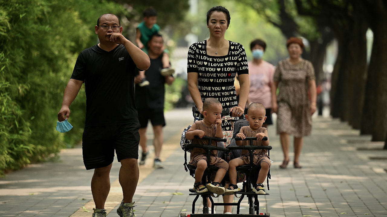 This file photo taken on August 2, 2022 shows a woman pushing a trolley with twins along a street in Beijing. Credit: AFP Photo