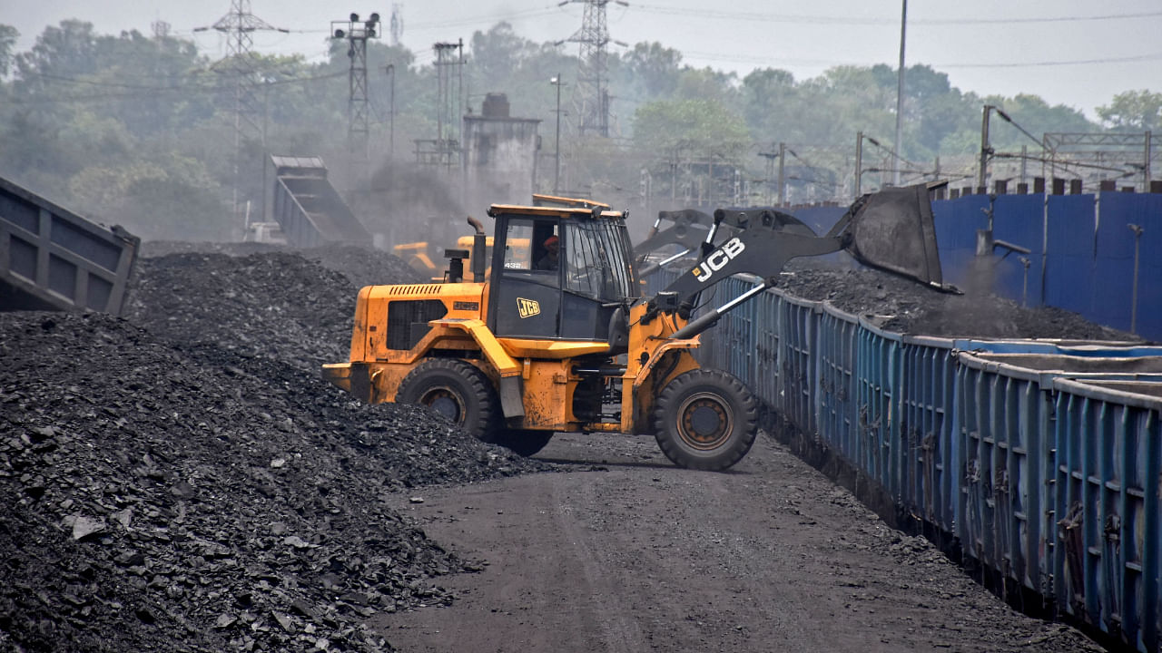 A worker operates a JCB machine to load coal onto a goods train at the Amrapali coal mines in Peeparwar in India's Jharkhand state on April 30, 2022. Credit: AFP File Photo
