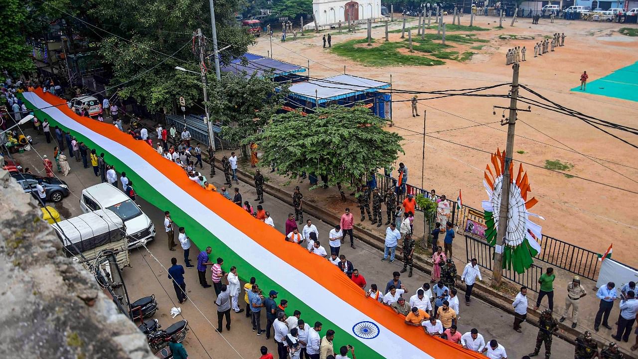 People carry a giant national flag after Assistant Commissioner M.G. Shivanna hoisted the national flag at Idgah maidan on the 76th Independence Day, in Bengaluru. Credit: PTI Photo