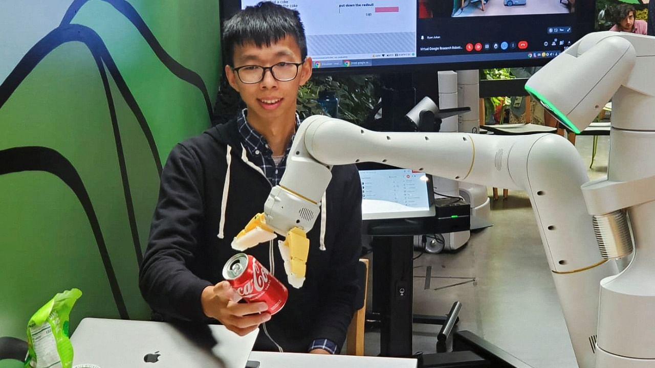 Google research scientist Fei Xia accepts a Coca-Cola can from a robot during a demonstration of AI technology at a company micro-kitchen in Mountain View. Credit: Reuters Photo