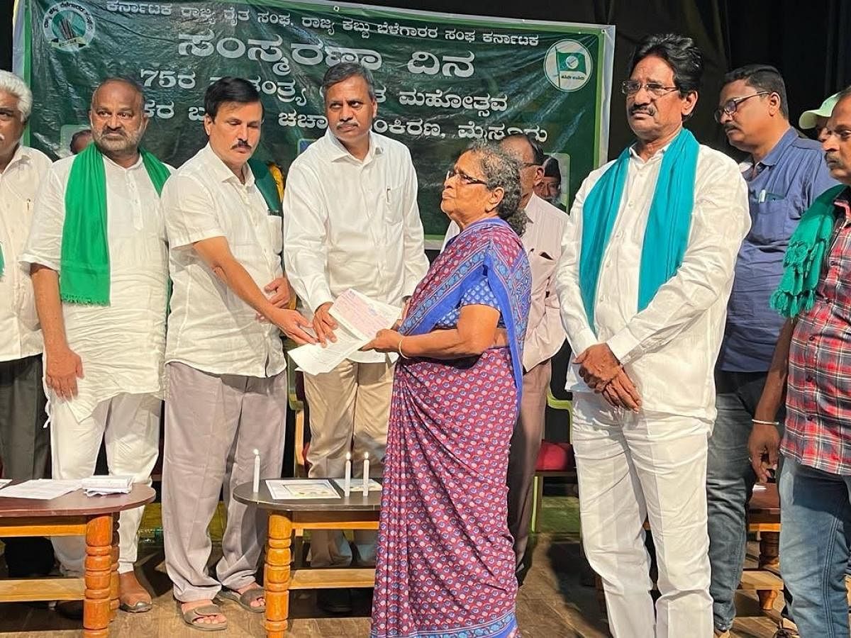 Telengana MLC Pallam Rajeshwara Reddy presents a cheque for Rs 10 lakh, on Tuesday, on behalf of Telangana government, to Thangamani, mother of farmer leader Vimal Kumar from T Narsipur, who died at Hyderabad, in February. Credit: DH Photo