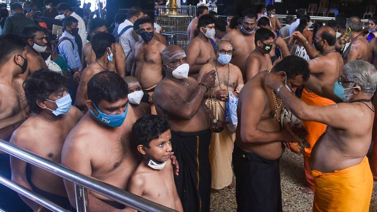  After the necessary rituals, the devotees were allowed to trek the holy hill, climb the 18 sacred steps and offer prayers before the main deity-Lord Ayyappa. Credit: PTI Photo