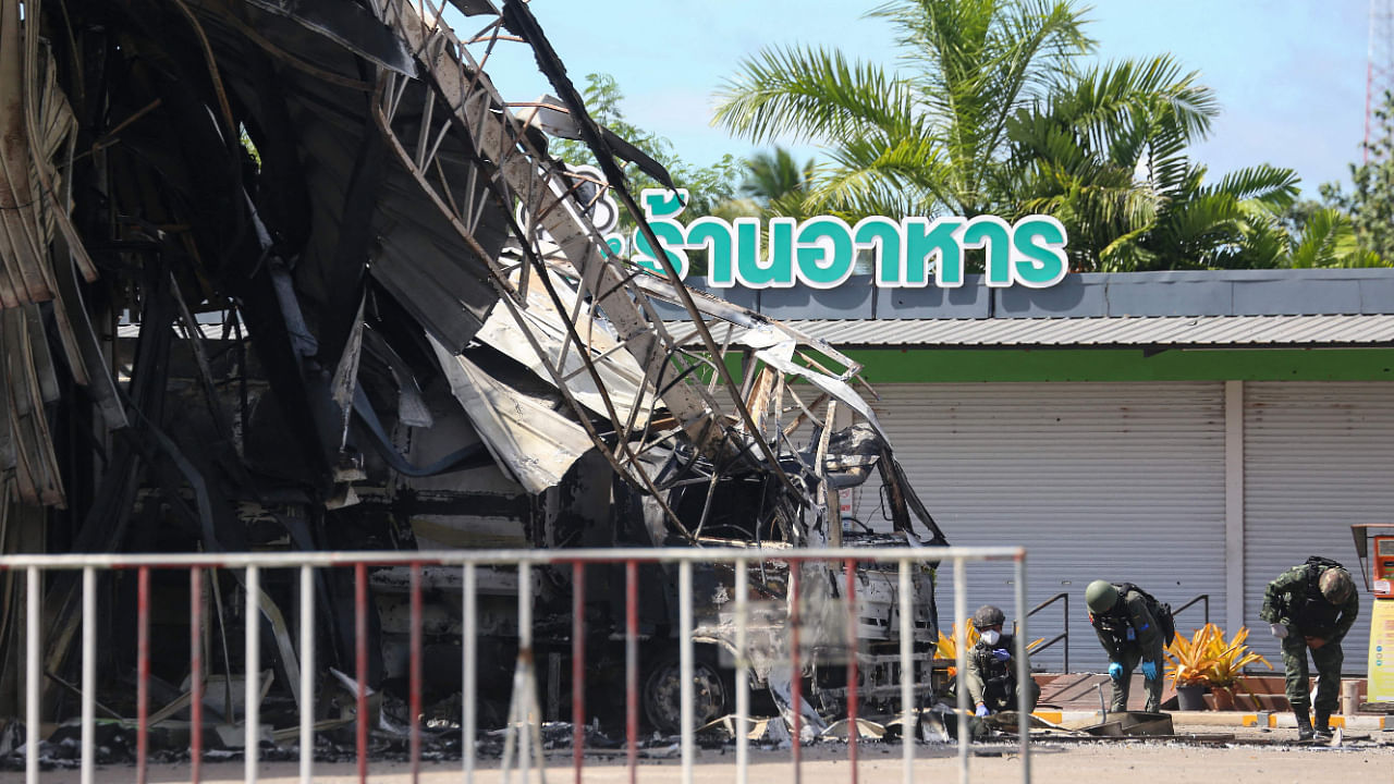 Thai bomb squad personnel inspect the damage at Bangchak gas station after an attack, in Nong Chik District in southern Thailand's Pattani province. Credit: AFP Photo