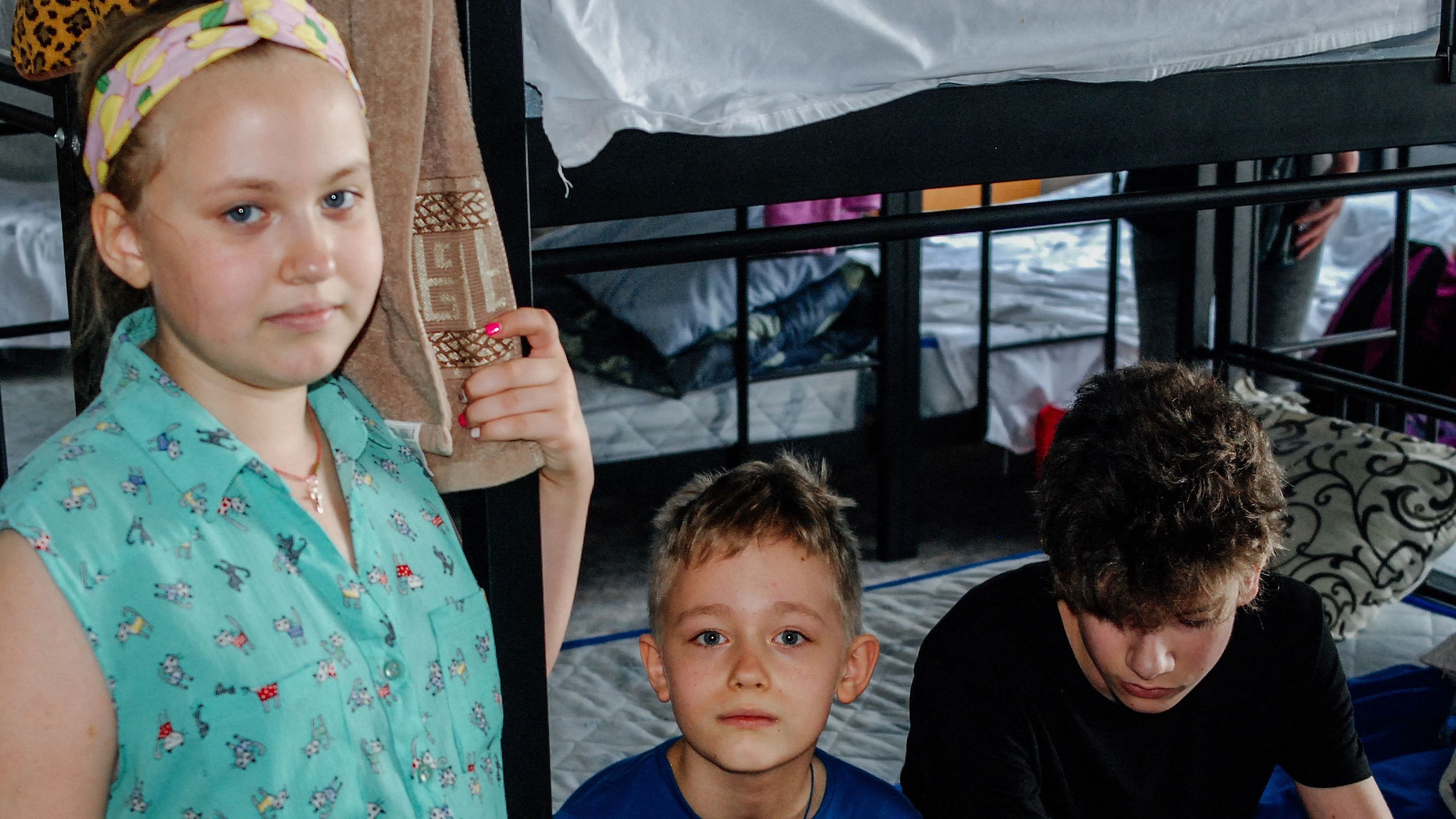Three children take a rest in the new opened support centre for migrants from the Kherson region "Ya Kherson" in Zaporizhzhia on August 14, 2022. - Driven out by the increased fighting, 24,000 Kherson residents have crossed to Zaporizhzhia in the past month, according to numbers from Ukrainian officials. Credit: AFP Photo