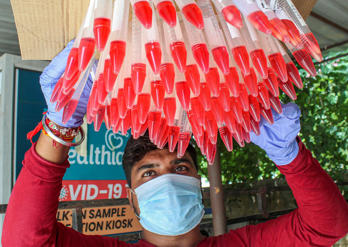 A healthcare worker with swab samples collected from people for Covid-19 testing. Credit: PTI Photo