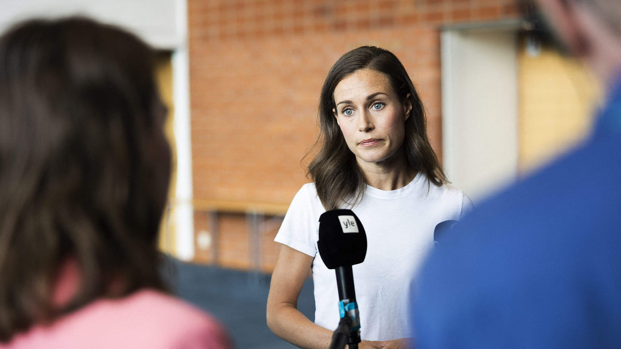 Prime Minister of Finland Sanna Marin (C) answers journalists' questions on August 18, 2022. Credit: AFP Photo