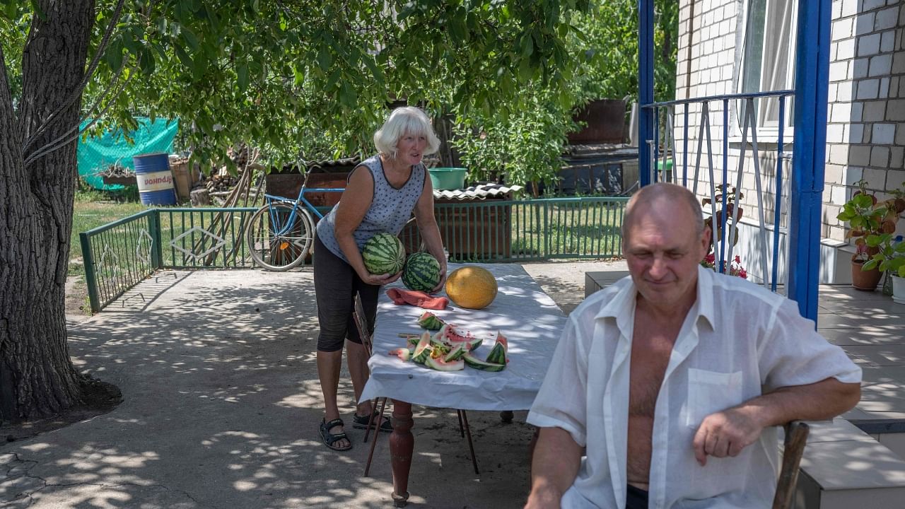Anastasiya Rudenko, widow of a late Chernobyl 'liquidator', prepares watermelon in her garden in Vyschetarasivka, across the river from the Zaporizhzhia atomic power plant. Credit: AFP Photo