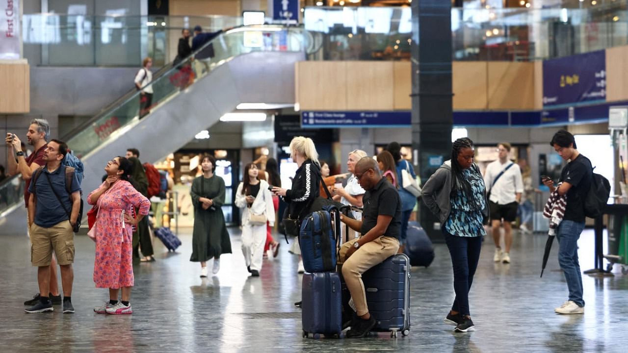 People look at departure information screens at Euston railway station, as railway workers strike over pay and terms, in London, Britain. Credit: Reuters photo