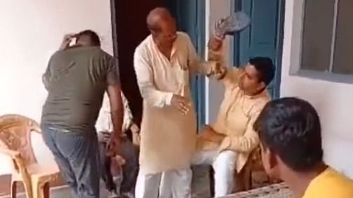 Video grab where two men, belonging to the upper caste can be seen thrashing a Dalit man with their shoes. Credit: Twitter/@MissionAmbedkar