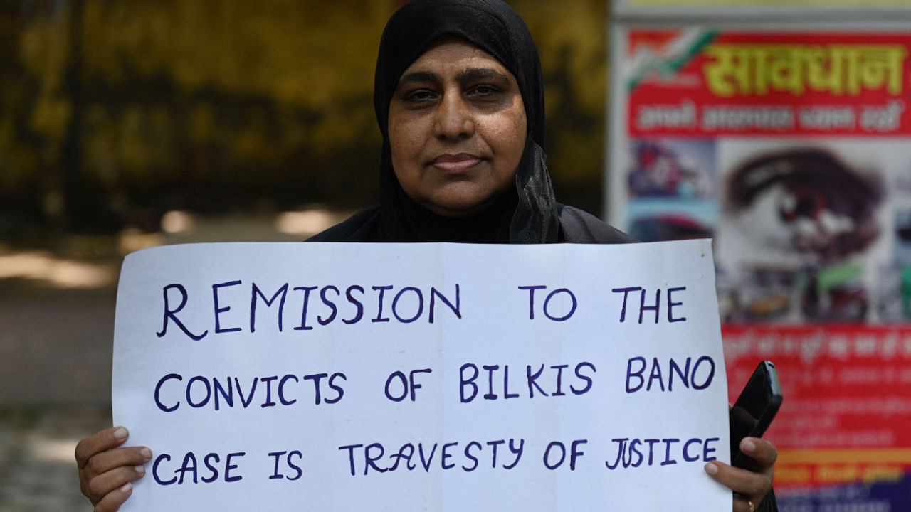 An activist holds a placard during a protest against the reease of the 11 convicts in the Bilkis Bano case. Credit: AFP Photo