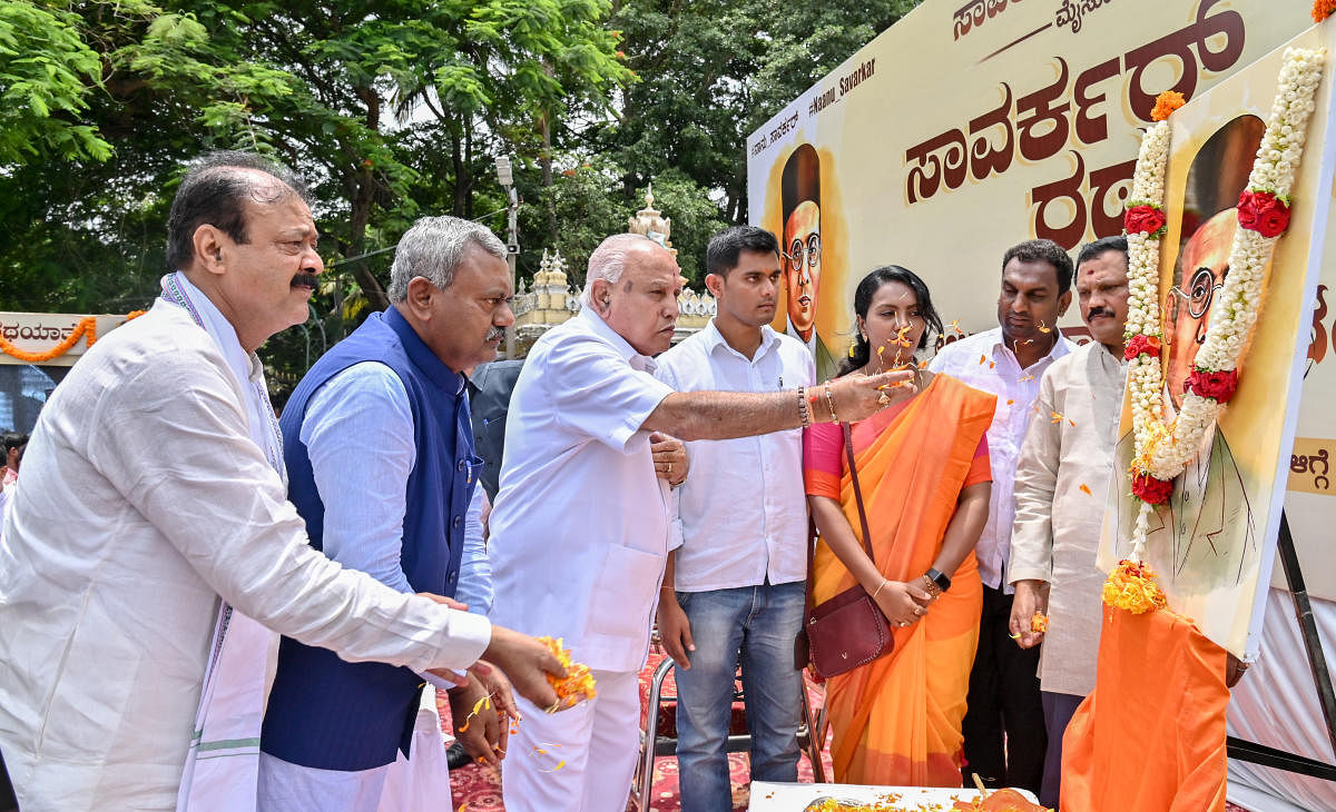 Former chief minister B S Yediyurappa pays floral tributes to a portrait of Savarkar before flagging off Savarkar Ratha Yartra in Mysuru on Tuesday. Ministers S T Somashekar and Narayana Gowda are seen. Credit: DH Photo/Anup Ragh T