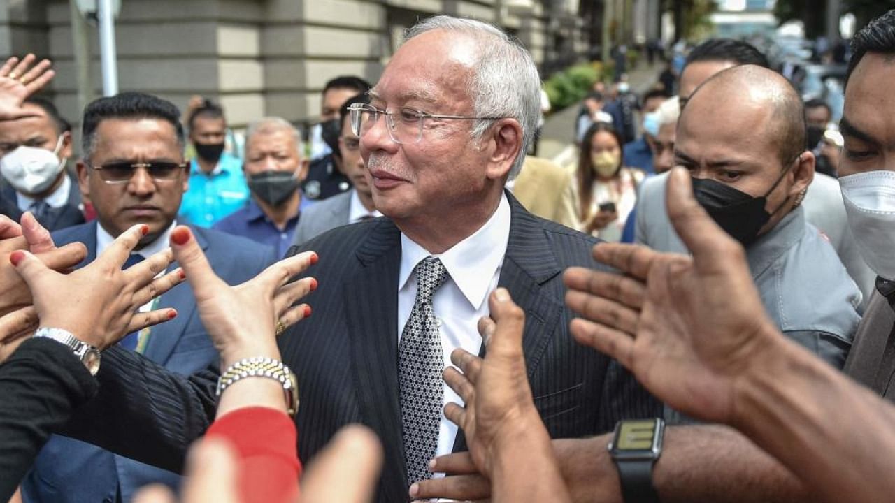 Malaysia's former prime minister Najib Razak (C) greets supporters as he walks out during a break in the trial during an appeal against his corruption conviction over the 1MDB financial scandal, at the federal court in Putrajaya, on August 23, 2022. Credit: AFP Photo