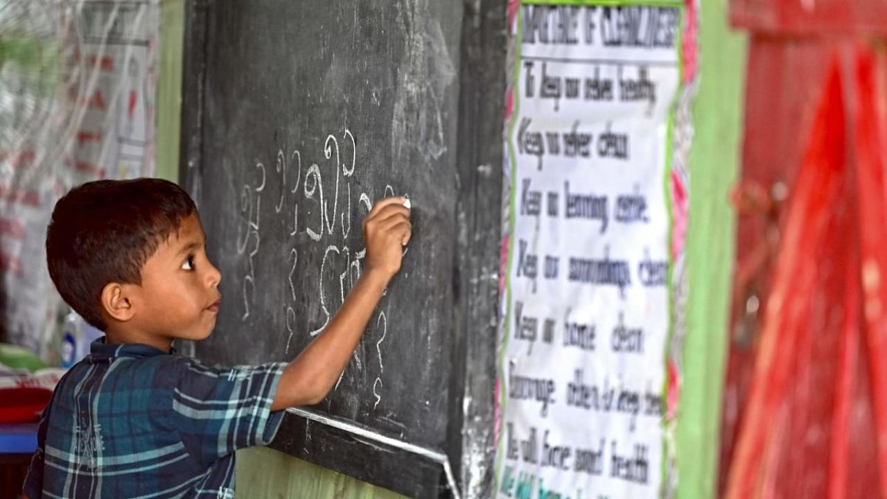 A Rohingya refugee child writes Rohingya language on a blackboard at a school in Kutupalong refugee camp in Ukhia. Credit: AFP Photo