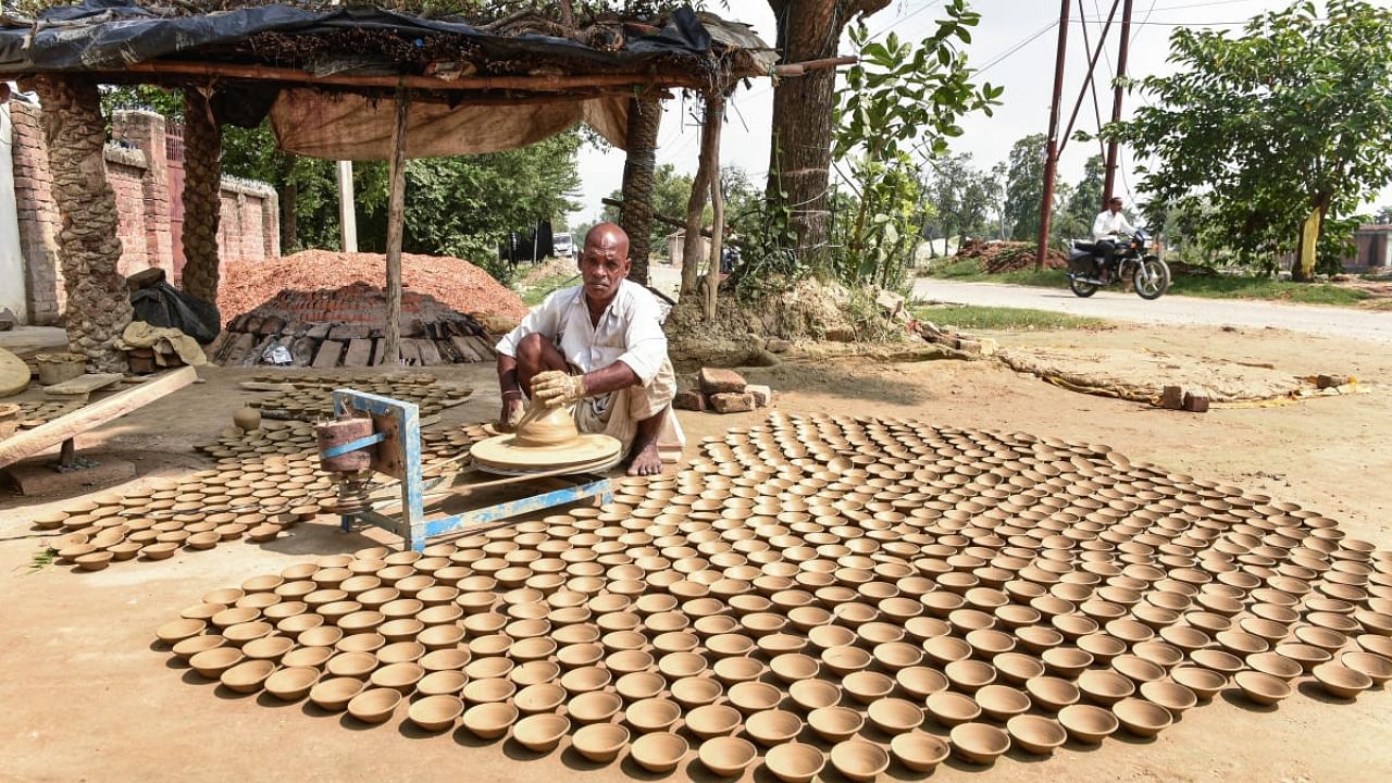 An artist prepares earthen lamps (diyas) to be used in the 'Deepotsav' festival 2022, in Ayodhya, Monday, Aug. 22, 2022. Credit: PTI Photo