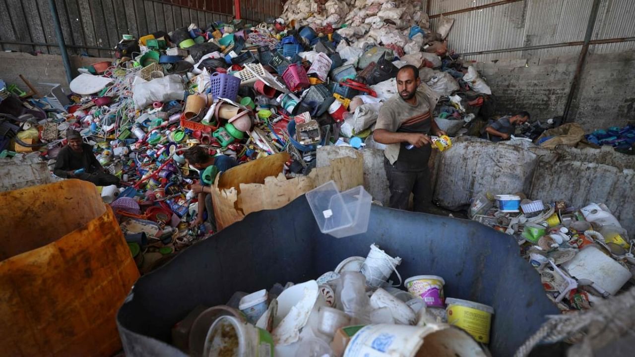 A Palestinian worker prepares plastic for processing to extract fuel in Jabalia on the northern Gaza Strip on August 23, 2022. Credit: AFP Photo