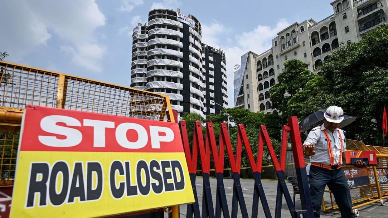 Police barricades cordon off a road near the 100-meter-high residential twin tower which is slated for demolition by controlled implosion on August 28, in Noida. Credit: AFP Photo