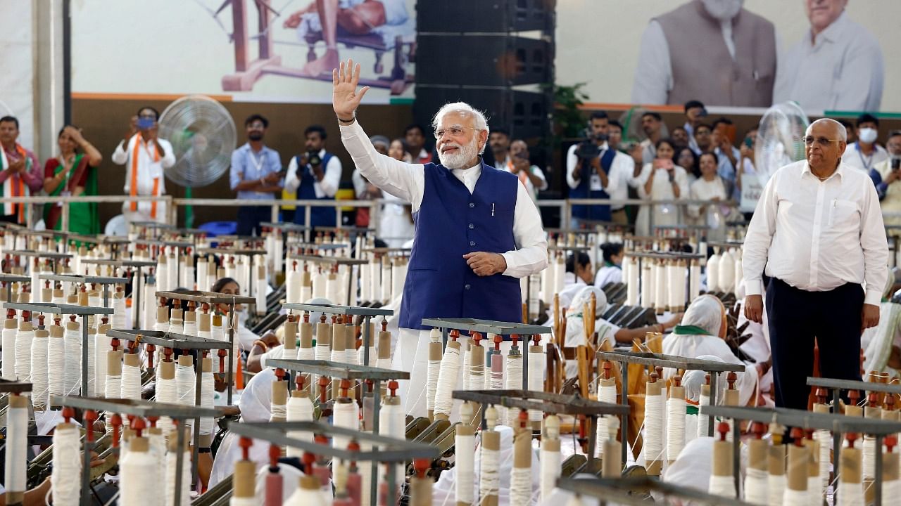 Prime Minister Narendra Modi waves towards supporters during 'Khadi Utsav' in Ahmedabad. Credit: PTI Photo