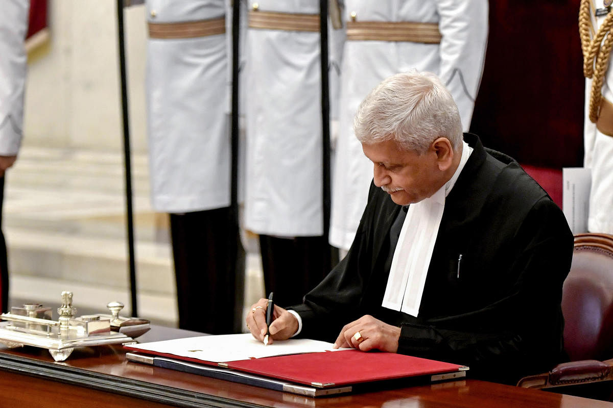 Justice U U Lalit signs the register after being sworn in as the CJI at Rashtrapati Bhavan. Credit: PTI Photo