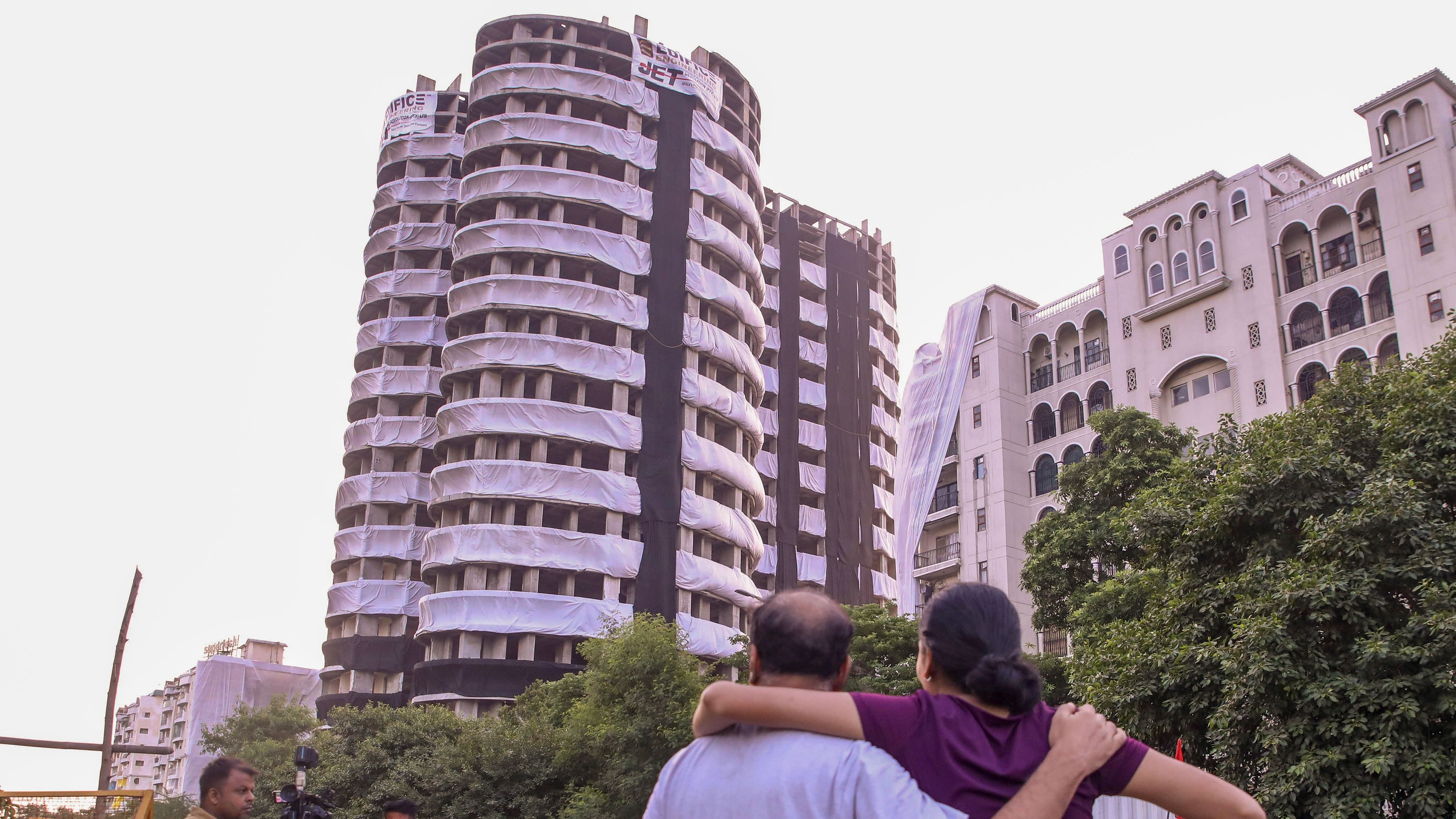 People vacating the area around Supertech twin towers look on ahead of the demolition with explosives in compliance with a Supreme Court order, in Noida. Credit: PTI Photo