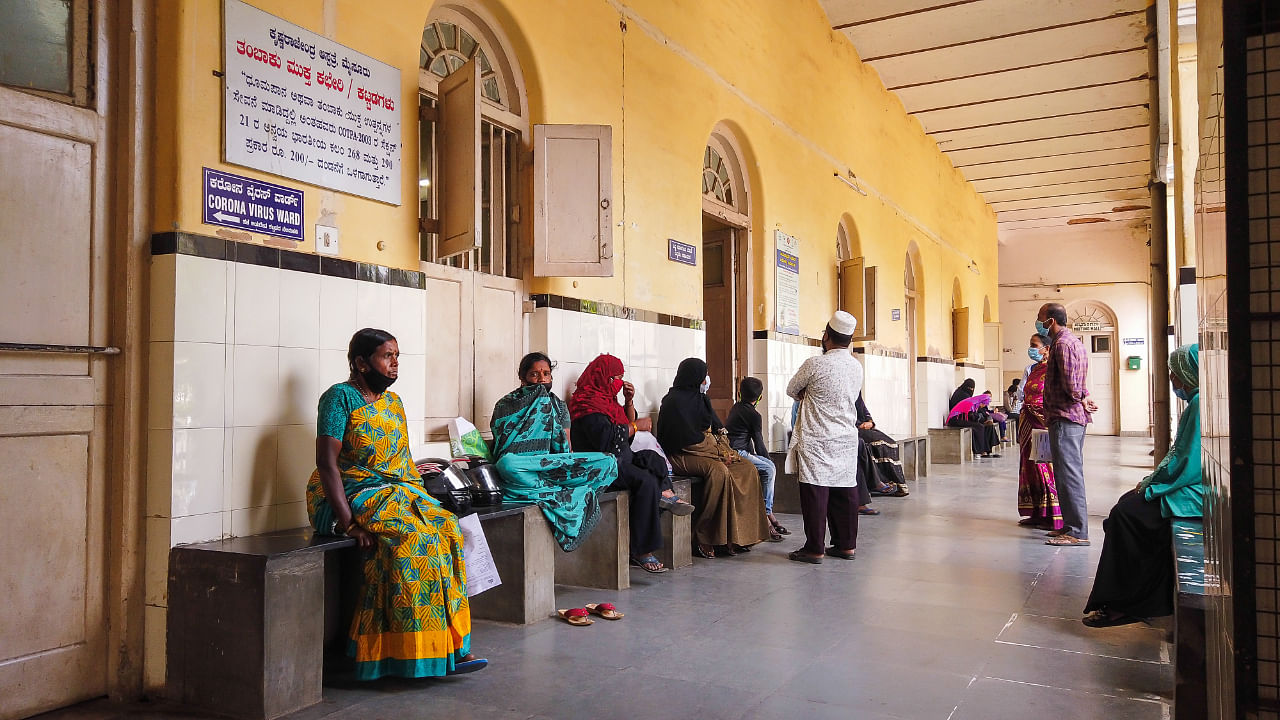 A hospital corridor view where patients are seen sitting and waiting for their turn for a preliminary Covid-19 medical test at Mysuru, Karnataka. Credit: DH File Photo