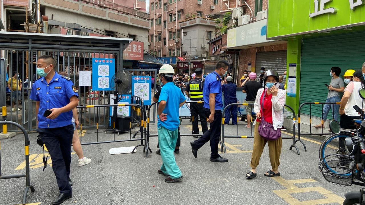 Security guards stand at an entrance to Wanxia urban village, which has been closed as part of Covid-19 control measures in Shenzhen. Credit: Reuters photo