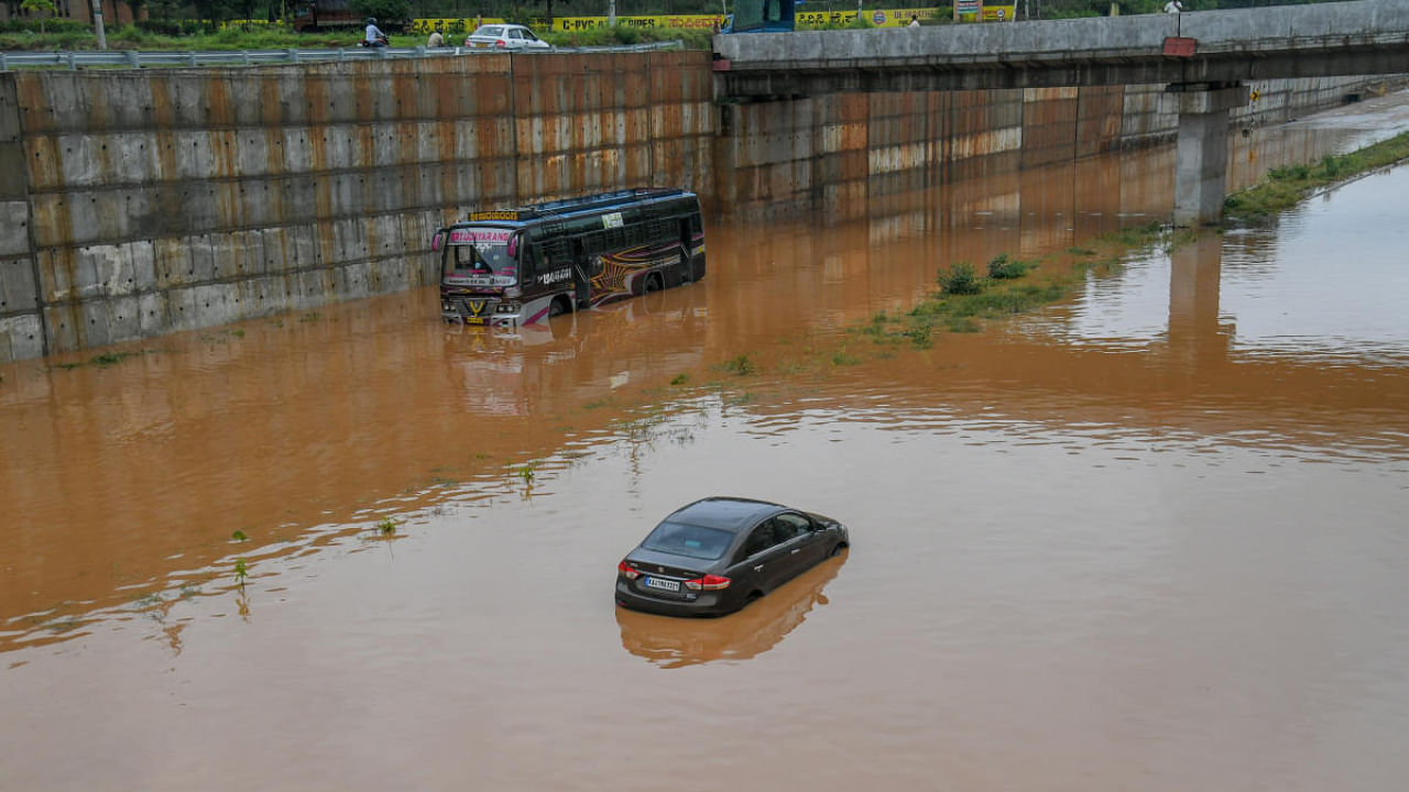 Vehicles stranded on a flooded road at Vaderahalli in Ramanagara district on Monday. Credit: DH Photo/ S K Dinesh