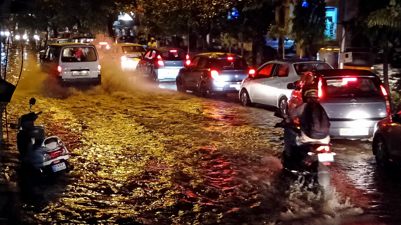 Cars plough along a flooded road in Bengaluru. Credit: DH Photo