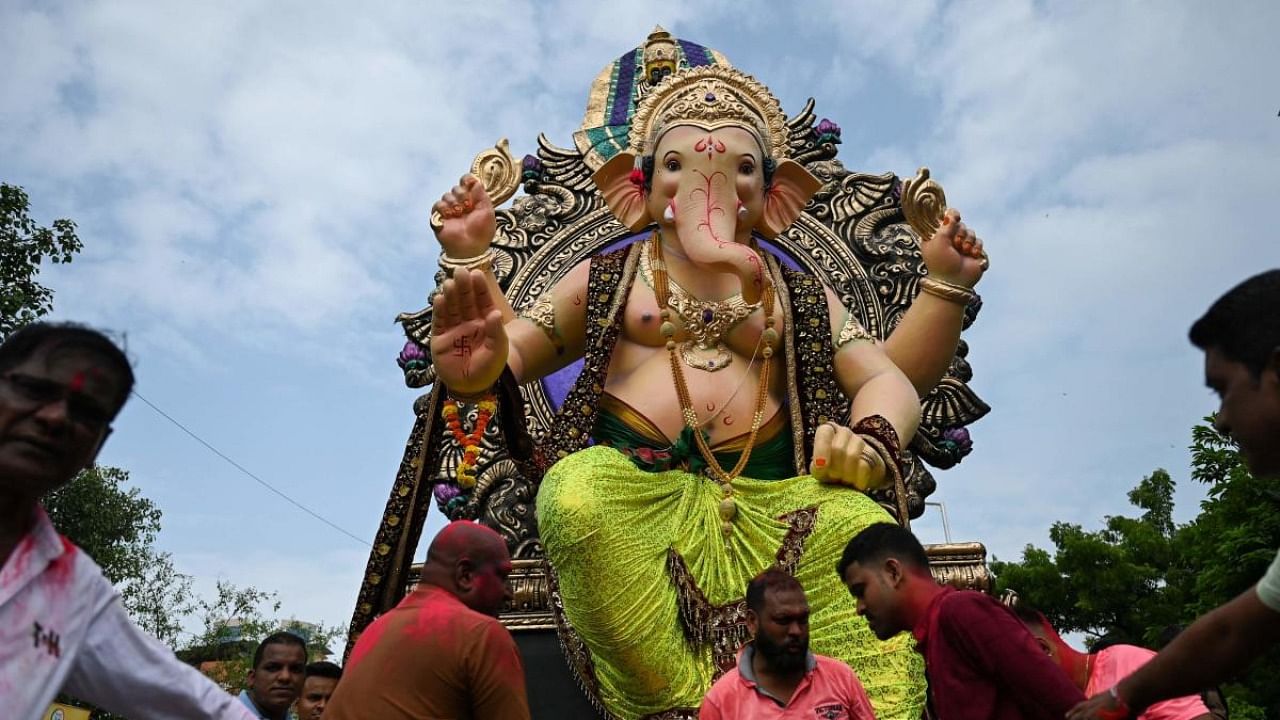 Devotees carry an idol of elephant-headed Hindu deity Ganesha during a procession ahead of the Ganesh Chaturthi festival in Mumbai on August 30, 2022. Credit: AFP Photo